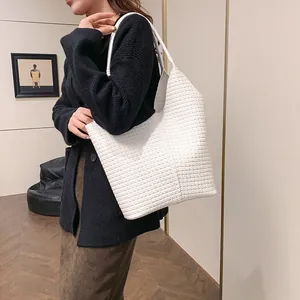 Close-up of white woven leather texture on a spacious tote bag for daily commute