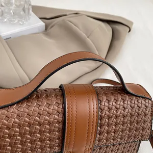 Detailed close-up of dark brown woven leather texture on a high-end shoulder bag