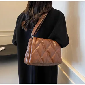 Vue arrière du mannequin portant le sac bandoulière matelassé marron style puffy