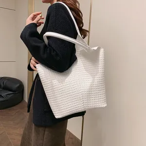 Detailed view of large white woven leather tote bag with thick handles for women