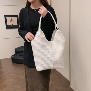 Detailed close-up of white woven texture and sturdy shoulder straps on the large tote bag