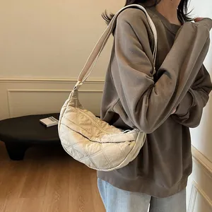 Detail showing cream quilted puffer crossbody bag with adjustable wide strap for daily commute