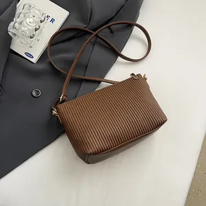 Dettaglio ravvicinato della trama a pieghe verticali di una borsa a tracolla marrone