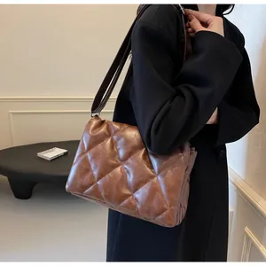 Vue détaillée de la texture en similicuir matelassé marron foncé avec grands losanges