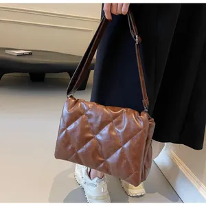 Détail d'un sac à bandoulière matelassé marron en cuir vintage souple avec boucle