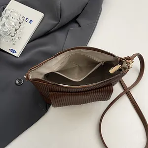 Interno della borsa a tracolla in velluto a coste marrone con tasca a zip
