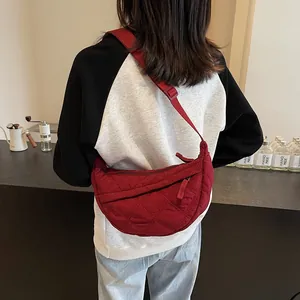 Close-up of a red quilted croissant bag showing soft diamond-stitched nylon fabric