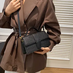 Detail of black woven texture on stylish PU leather evening handbag with gold hardware