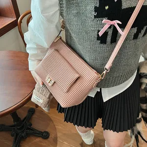 Borsa a spalla in velluto rosa con chiusura dorata indossata da una modella per stile
