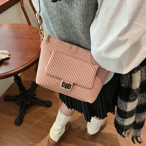Dettaglio borsa a tracolla plissettata rosa con chiusura a girello dorata e ganci metallici