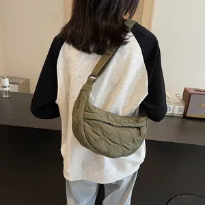 Quilted green crescent bag with adjustable wide strap shown from a back perspective