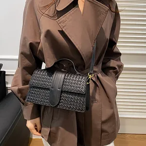 Close-up of black woven leather handbag with gold metal hardware and smooth strap detail