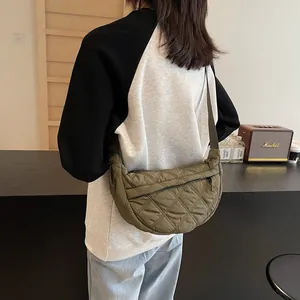 Detailed back view of model wearing a green quilted crescent bag with adjustable strap