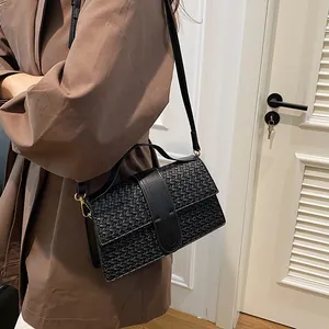 Detailed view of black woven texture leather handbag with elegant gold metal hardware