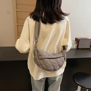 Rear view of a model wearing the grey quilted crescent shoulder bag for daily commuting