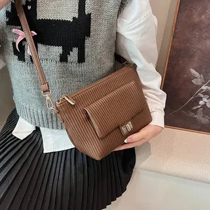 Dettaglio borsa a tracolla vintage marrone con trama a righe e chiusura a girello dorata