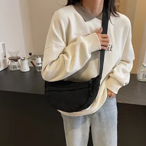 Lifestyle view of a black quilted nylon crescent bag with wide shoulder strap