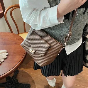 Dettaglio della borsa vintage marrone con pieghe verticali e chiusura dorata