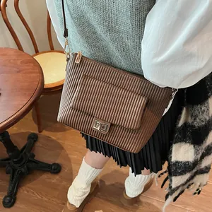 Dettaglio ravvicinato della borsa vintage marrone con texture a pieghe e chiusura in metallo