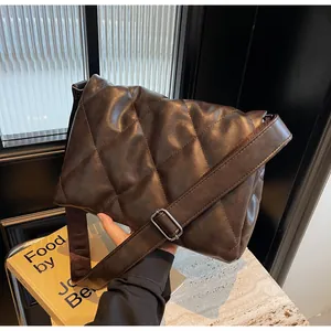 Gros plan du sac matelassé marron en similicuir avec large bandoulière et boucle