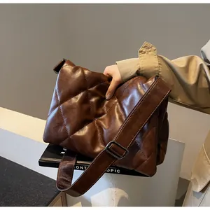 Détail du sac bandoulière matelassé marron foncé avec sangle large et boucle en métal
