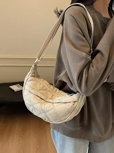 Beige quilted crescent shoulder bag with adjustable strap for women in casual style