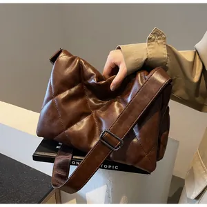 Détail du sac bandoulière matelassé marron foncé avec grandes coutures en losange
