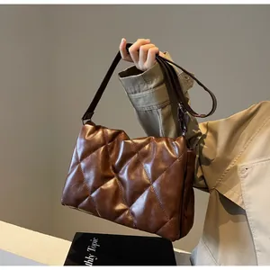 Détail du sac bandoulière matelassé marron foncé avec texture souple et sangle réglable
