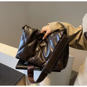 Détail du sac à bandoulière matelassé marron foncé avec texture en cuir souple et sangle réglable