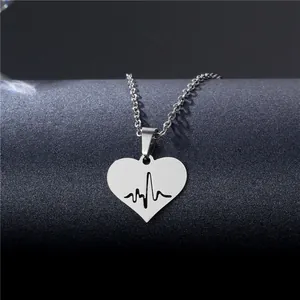 Minimalist silver stainless steel heart necklace with ECG heartbeat cutout on a black stand