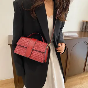 Close-up of vintage red woven rectangular handbag with golden hardware and leather strap