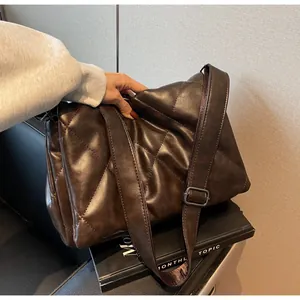 Détail du sac bandoulière matelassé marron foncé avec texture souple et large sangle