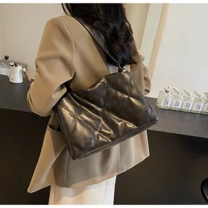 Détail du sac à bandoulière matelassé noir avec coutures en losange et large sangle