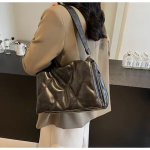 Détail d'un sac à bandoulière matelassé en cuir mat avec large sangle pour femmes