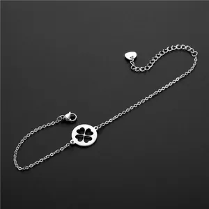Détail du bracelet chaîne en acier argenté avec trèfle évidé et breloque cœur