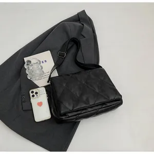 Détail du sac bandoulière matelassé noir avec coutures en losanges et fini mat