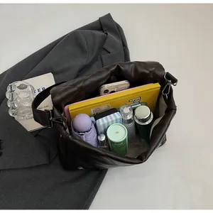 Vue de dessus du sac bandoulière matelassé marron montrant un intérieur spacieux organisé