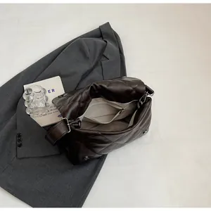 Détail de l'intérieur du sac matelassé avec doublure beige et une poche zippée fonctionnelle