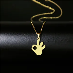 Macro shot of 18K gold plated OK gesture pendant on minimalist O-link chain necklace
