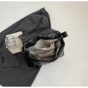 Vue intérieure du sac bandoulière matelassé noir avec poche zippée et compartiments