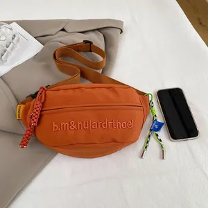 Detailaufnahme der orangefarbenen Gürteltasche aus Segeltuch mit Stickerei