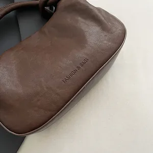 Detailed macro shot of dark brown leather texture and embossed FASHION & BAGS logo