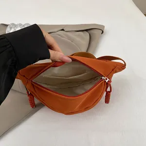 Detailansicht des Innenfachs und des gewebten Reißverschlusses dieser orangefarbenen Tasche