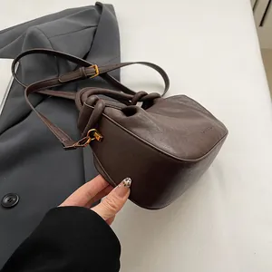 Detail of dark brown leather bag showing gold hardware and FASHION & BAGS embossed logo