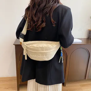 Detail der beige Segeltuch-Gürteltasche mit Stickerei und gewebten Reißverschlusszügen
