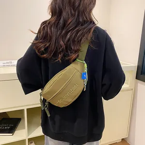 Detailansicht der olivgrünen Segeltuch-Brusttasche mit Stickerei und Zierkordeln