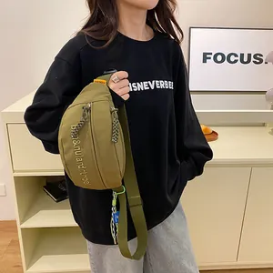 Details der armee-grünen Brusttasche mit Buchstabenstickerei und gewebtem Reißverschluss