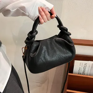 Detail of black pleated cloud bag with knotted handle and fine leather texture