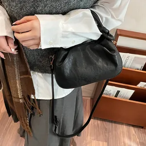 Detail of black pleated cloud bag featuring Fashion & Bags logo and slim shoulder strap