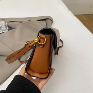 Vista laterale della borsa baguette retrò con tela a motivi vintage e dettagli in pelle
